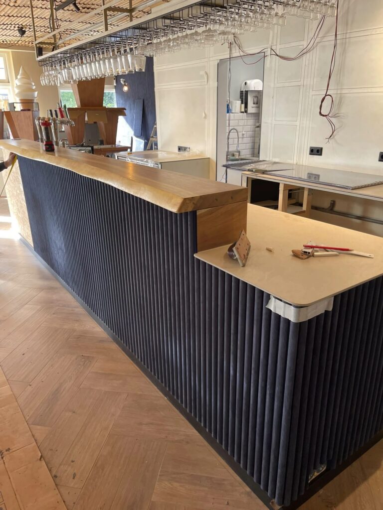 Bar met donkerblauwe ribbelpanelen en een blad van massief hout