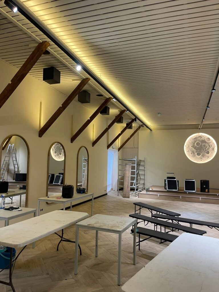 Zaal met podium, boogspiegels en een maanlamp