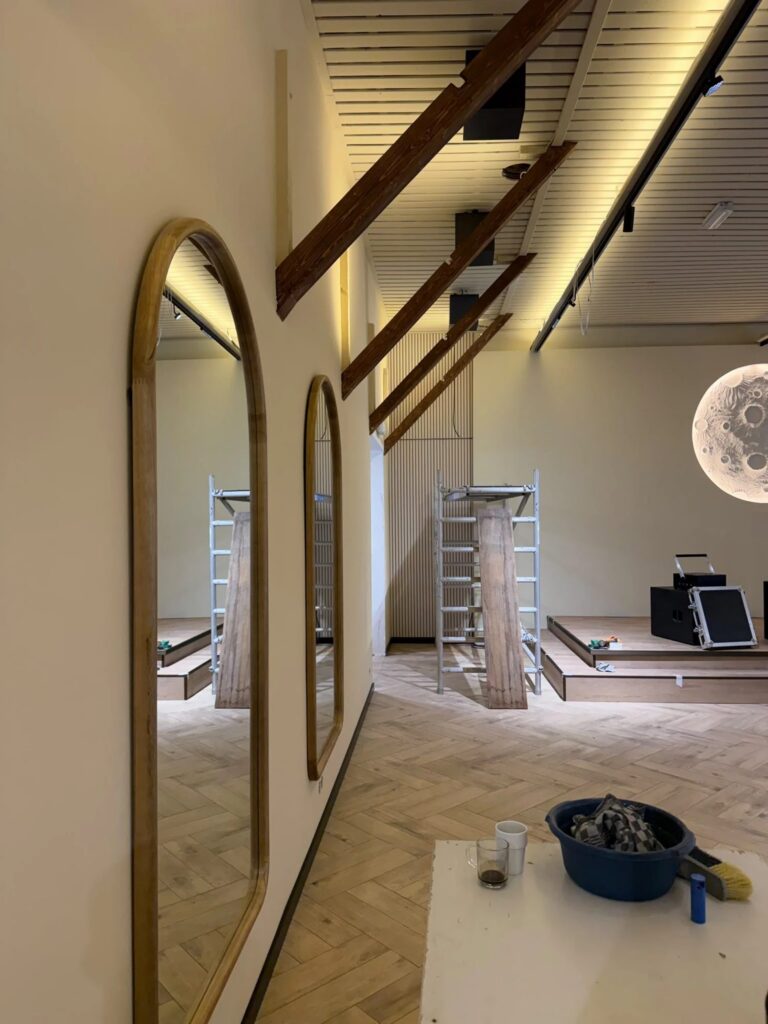 Zaal met boogspiegels, houten balken en een lichtplafond